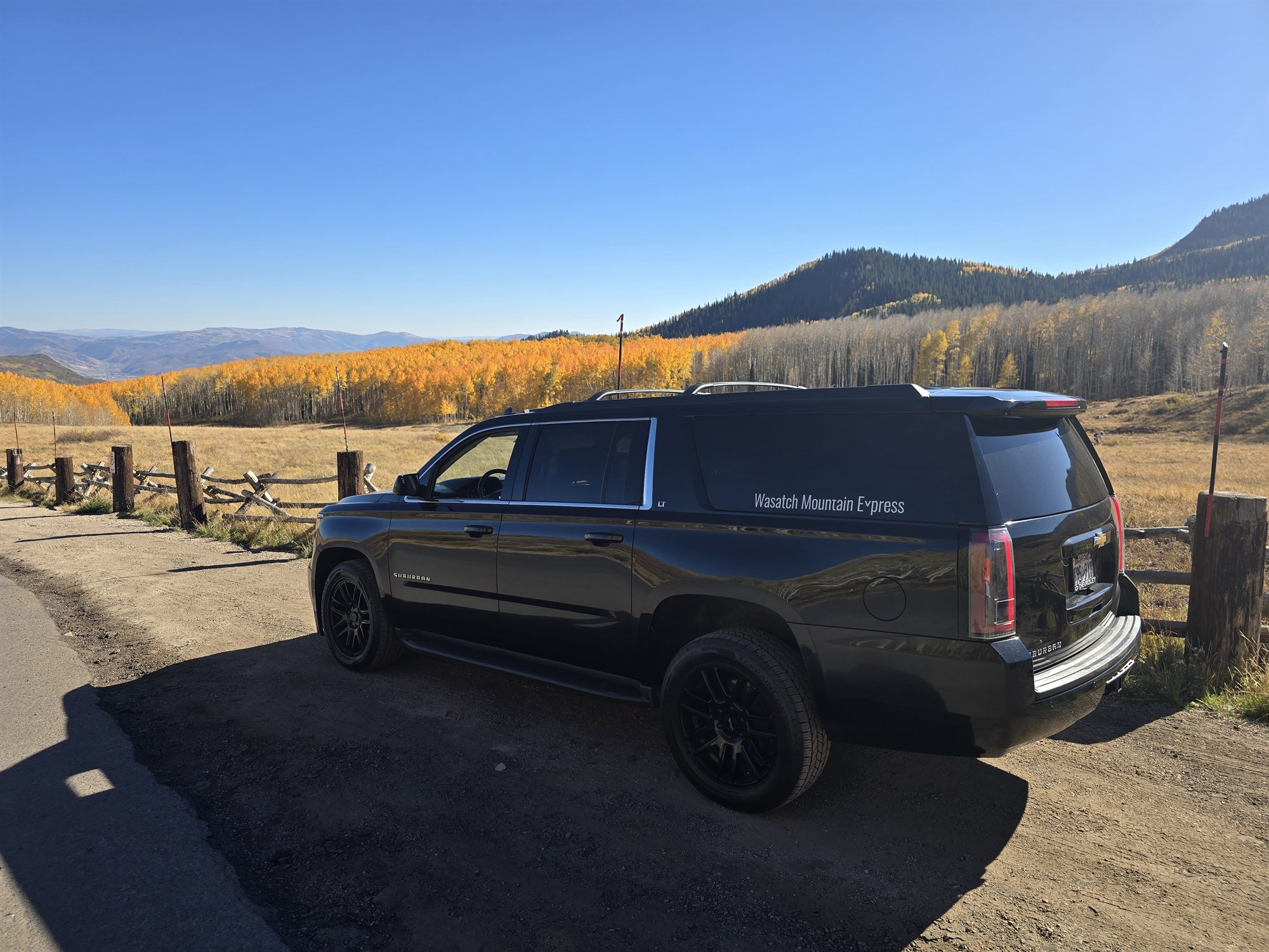 A full-size SUV parked in front of autumn aspens