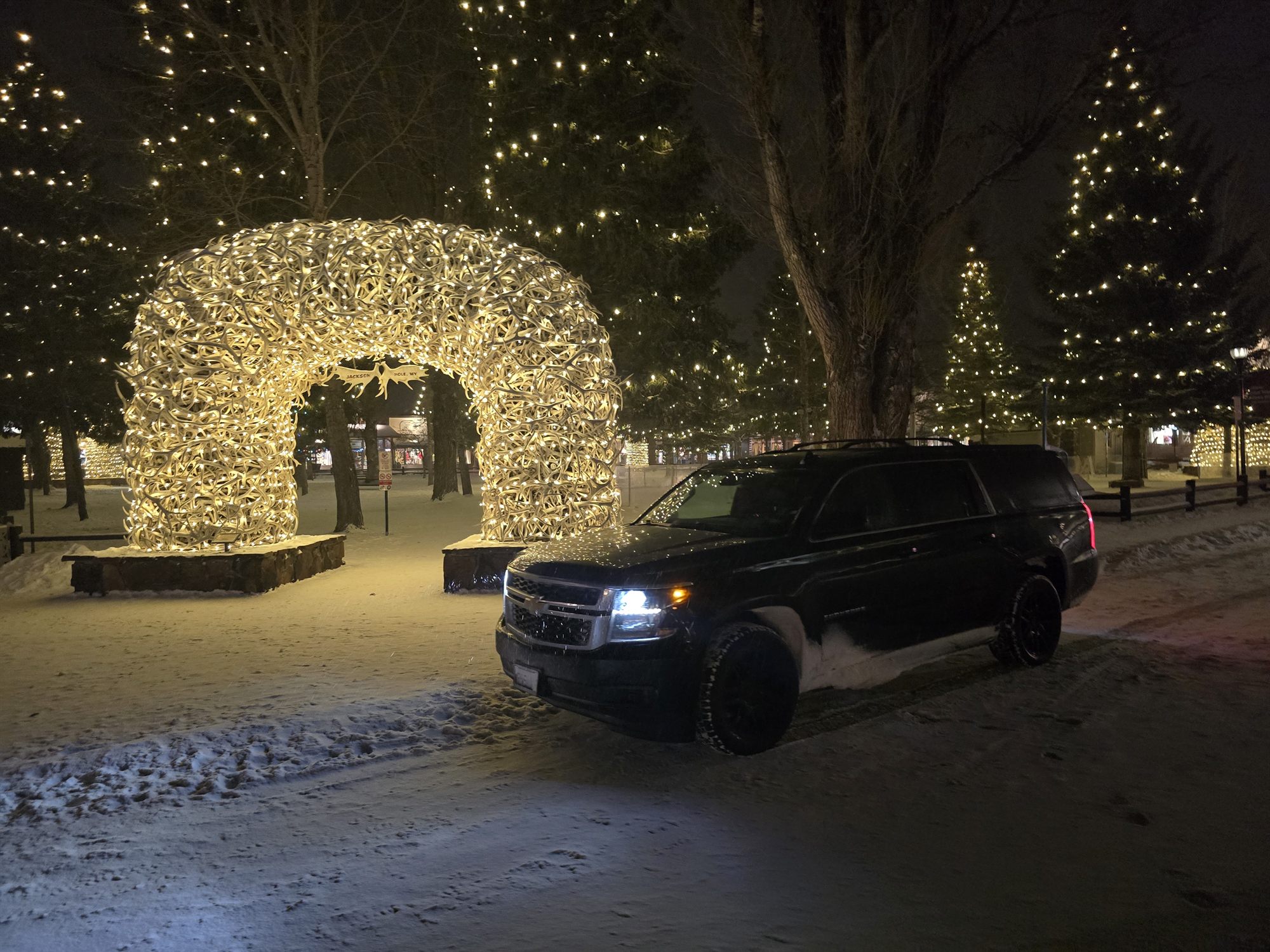 The SUV beside the lit antler arch in Jackson, Wyoming, at night