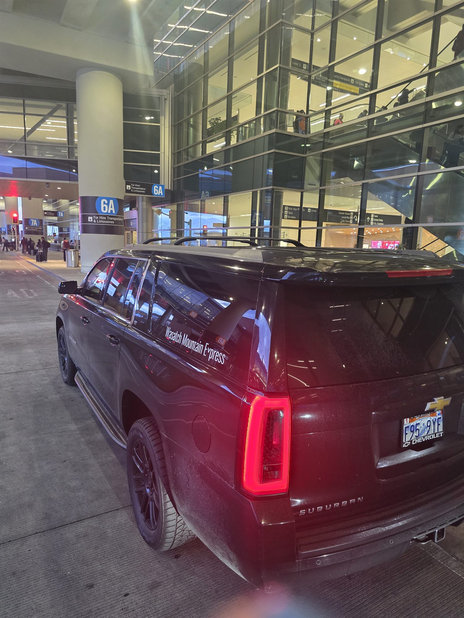The SUV waiting at the SLC ground transportation curb beside the column 6A sign